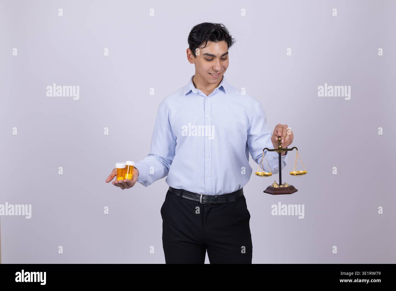 Ein Mann, der Orange und Apfel auf der Waage der Gerechtigkeit vergleicht Stockfoto