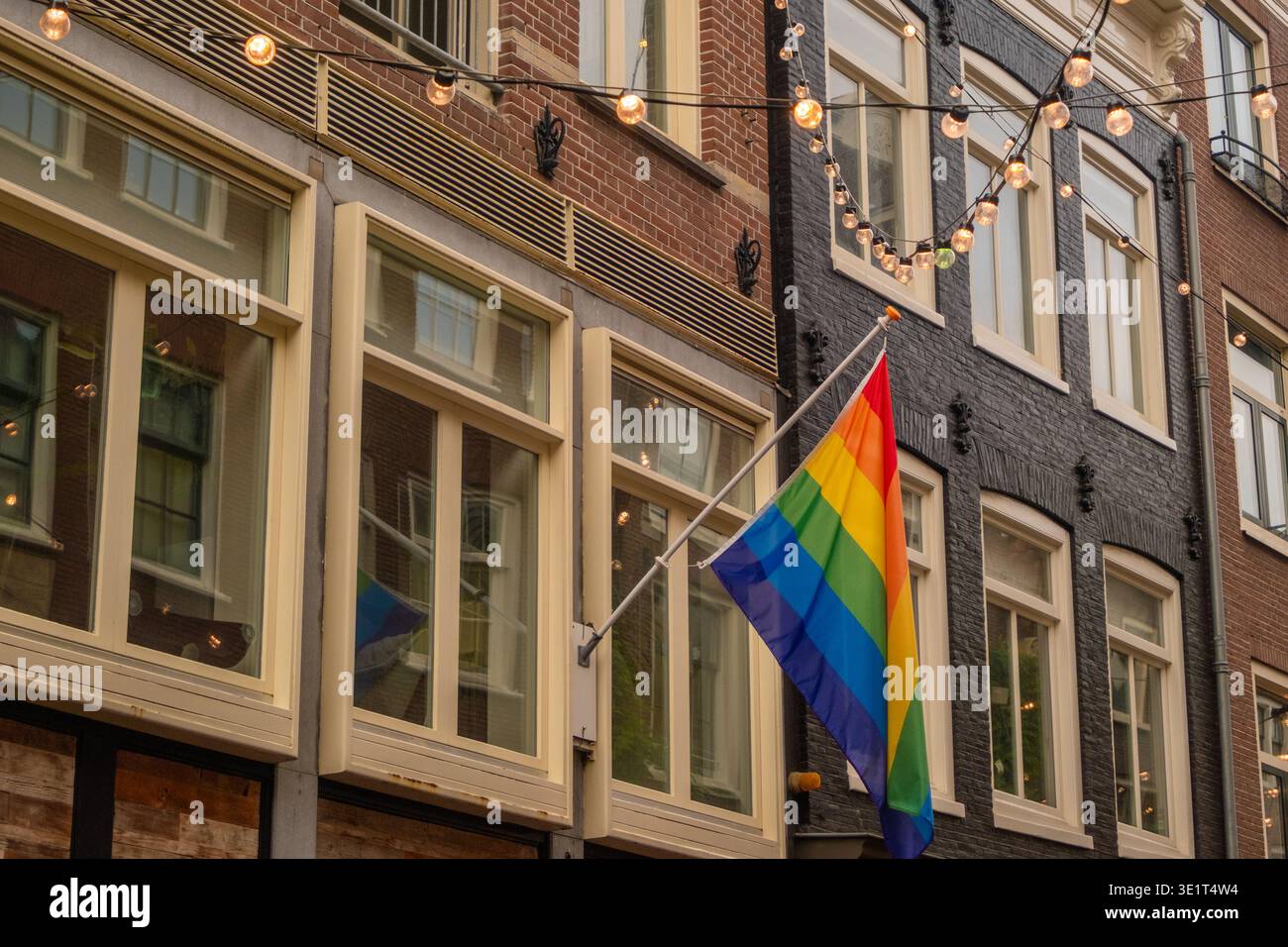 Farbenfrohe Fahnen und warme Lichter in den Straßen von Amsterdam im Herbst Stockfoto