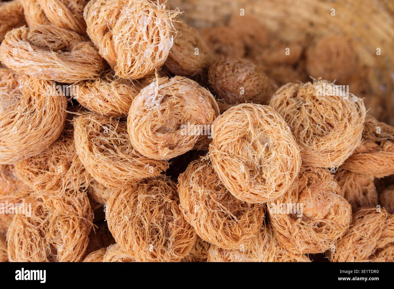 Nahaufnahme eines Haufens knuspriger, goldbrauner Feni-Süßigkeiten, ein traditionelles gehacktes Gebäck, das oft auf den Märkten und Bäckereien von Udaipur zu finden ist. Stockfoto