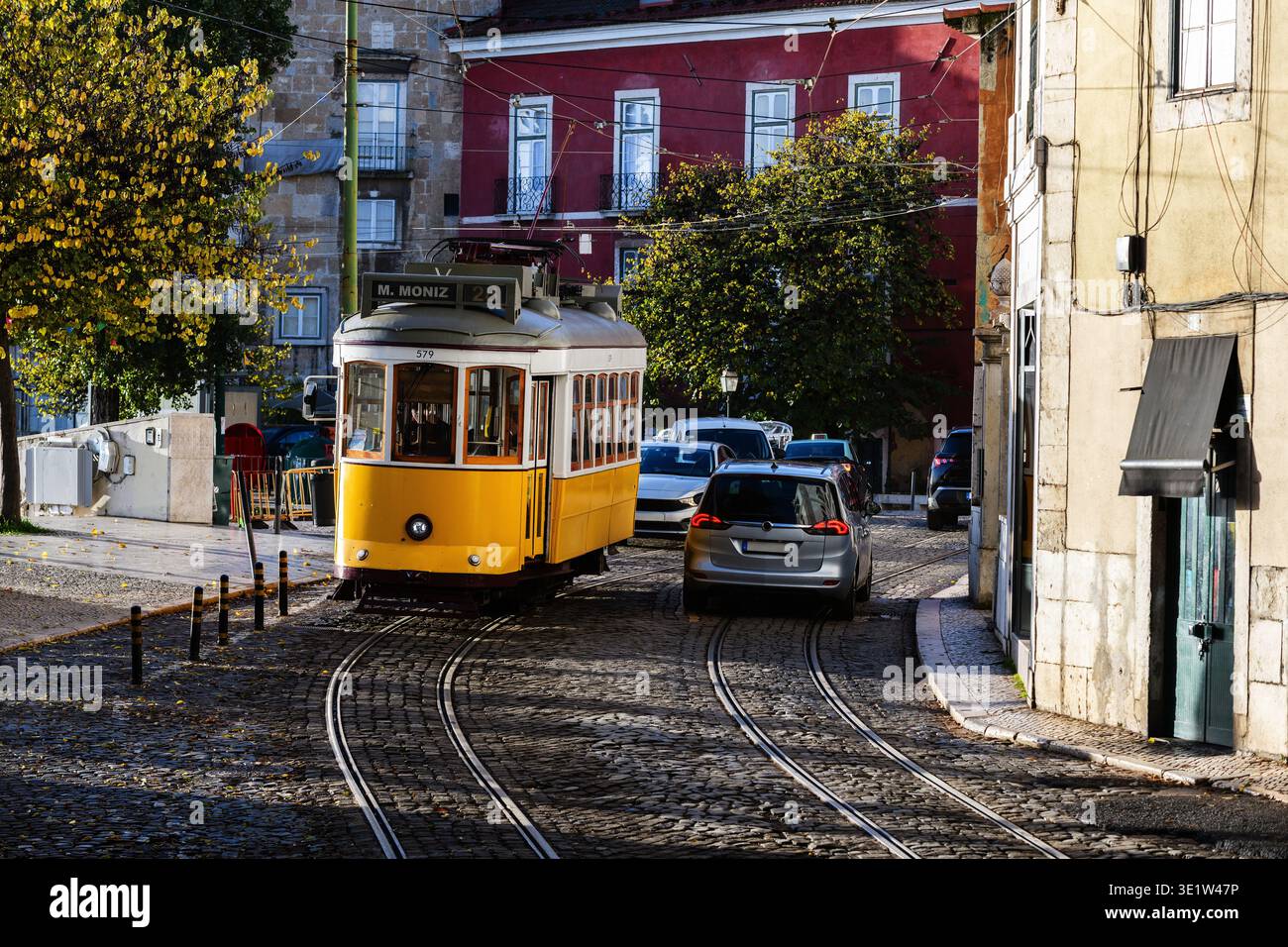 Beliebte Straßenbahnlinie 28 entlang einer kopfsteingepflasterten Straße im historischen Viertel Alfama in Lissabon, Portugal. Stockfoto