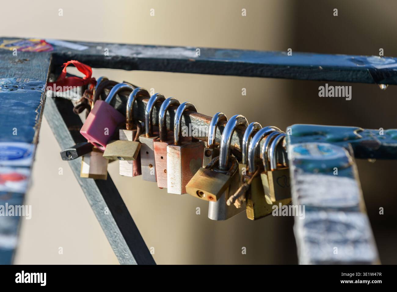 Liebesschlösser oder Liebesvorhängeschlösser symbolisieren die Liebe zwischen zwei Partnern, die an einem Metallgeländer auf einer Brücke in Lissabon, Portugal, befestigt sind. Stockfoto