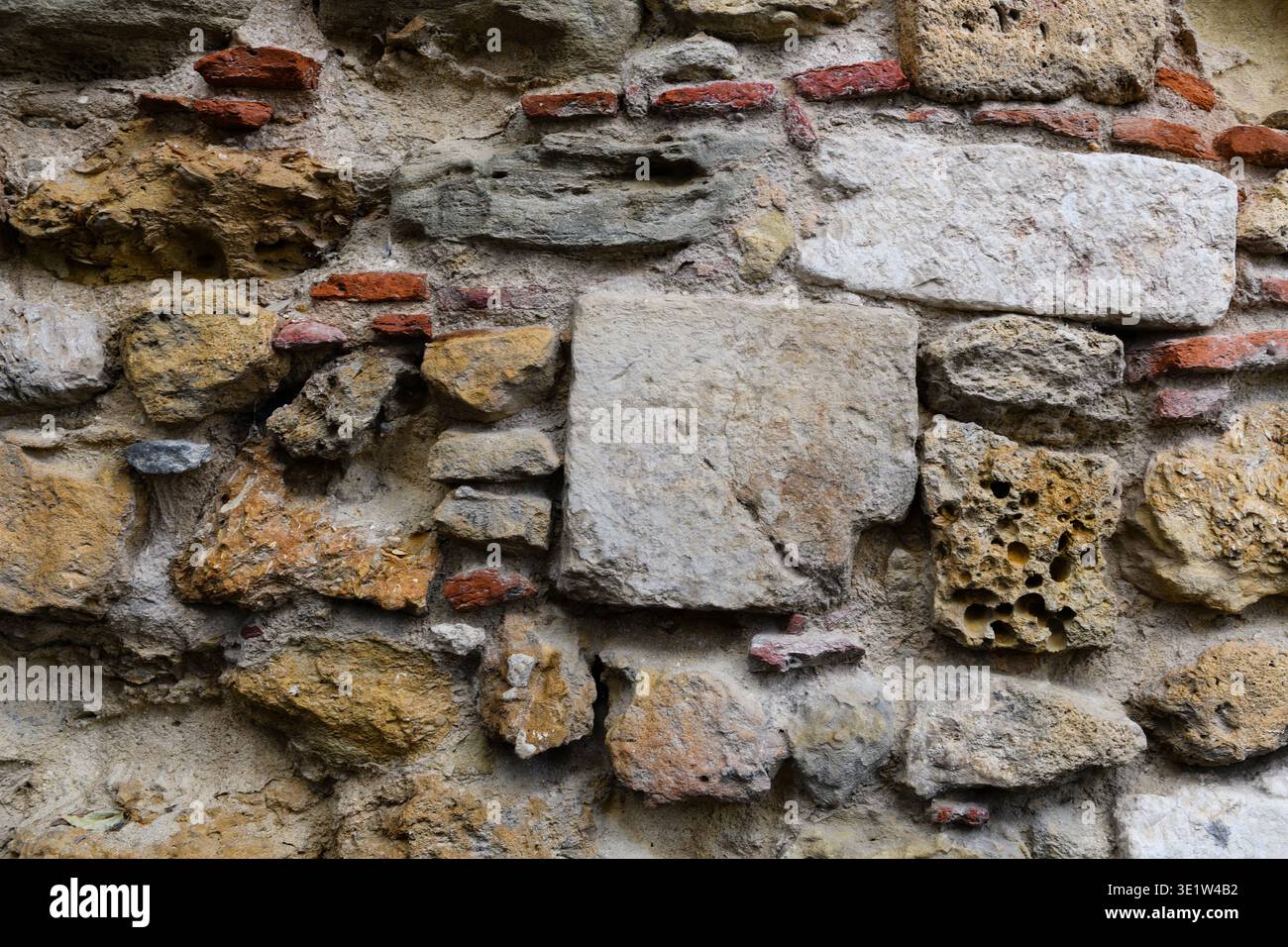Strukturiertes, abstraktes Muster aus alten, verwitterten Ziegelsteinen und Steinmauern auf einem Gebäude im historischen Stadtteil Alfama in Lissabon, Portugal. Stockfoto