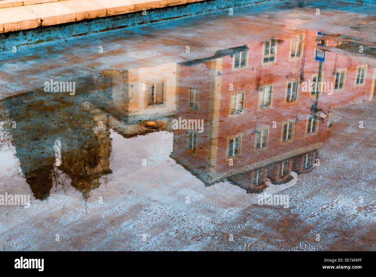 Sanfte, abstrakte Reflexion im Regenwasser der bunten, pastellfarbenen Gebäude des historischen Alfama-Viertels in Lissabon, Portugal. Stockfoto