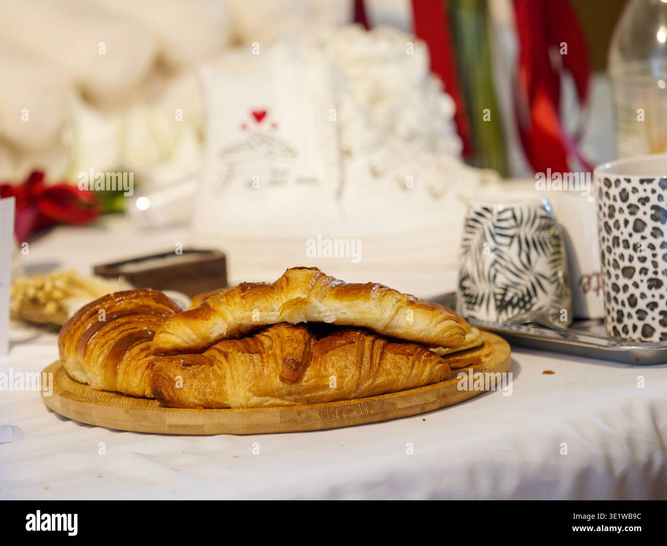 Nahaufnahme von frisch gebackenen Croissants auf einem Holzbrett mit goldenem Blätterteig in gemütlichem Frühstücks- oder Brunch-Ambiente. Stockfoto