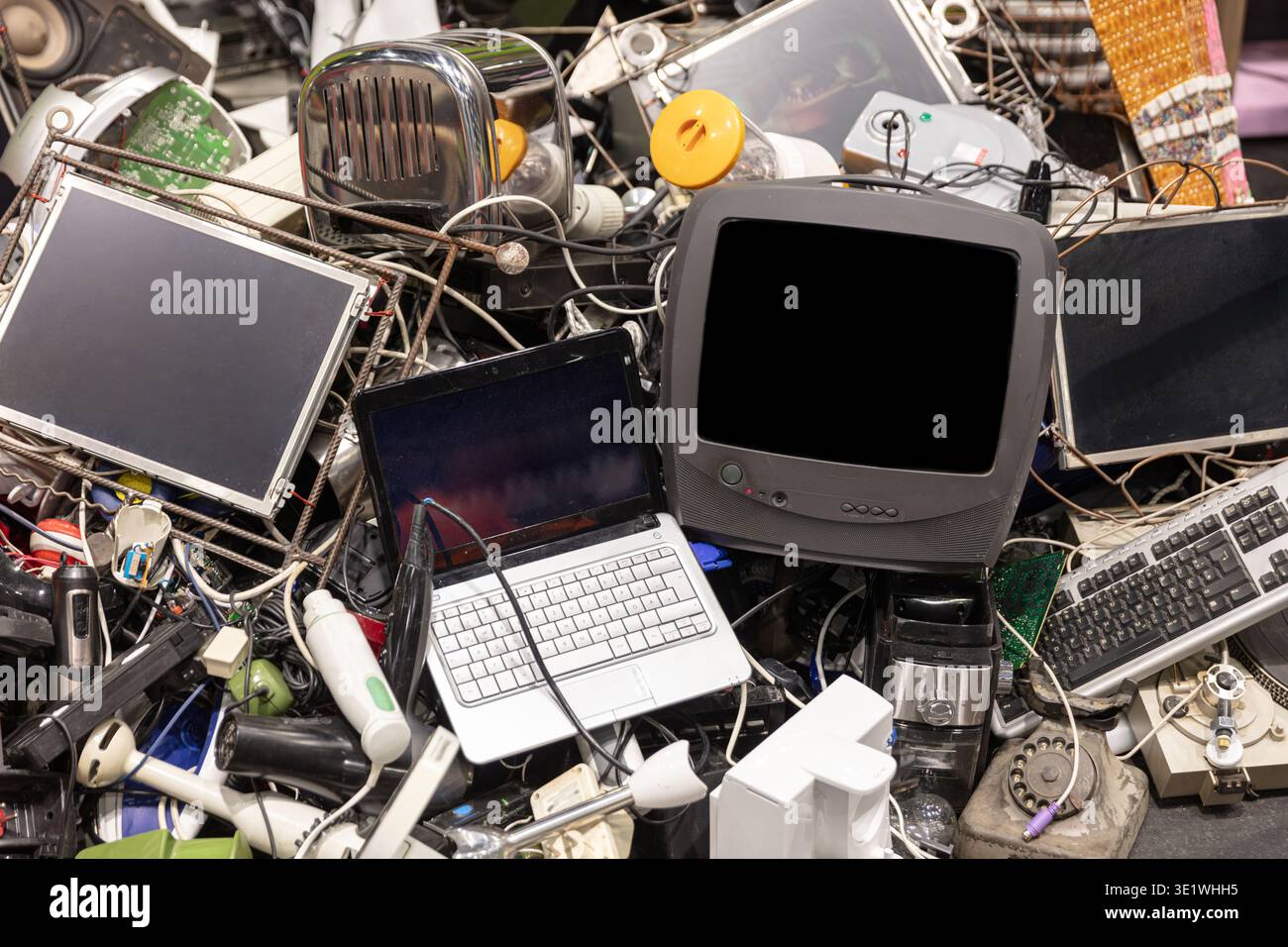 Es wird ein Stapel von weggeworfenen Elektroschrott gezeigt, einschließlich einer Laptop-TV-Tastatur und anderer veralteter Geräte. Dieses Bild kann für Konzepte r verwendet werden Stockfoto