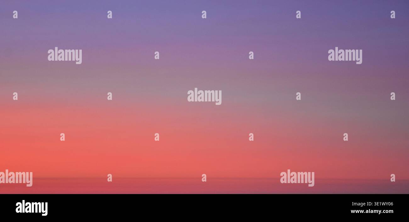 Blick in die Höhe eines dramatischen Abendhimmels mit tiefblauen und violetten Tönen mit weichen, nebeligen Wolken und subtilen Lichtverläufen. Stockfoto