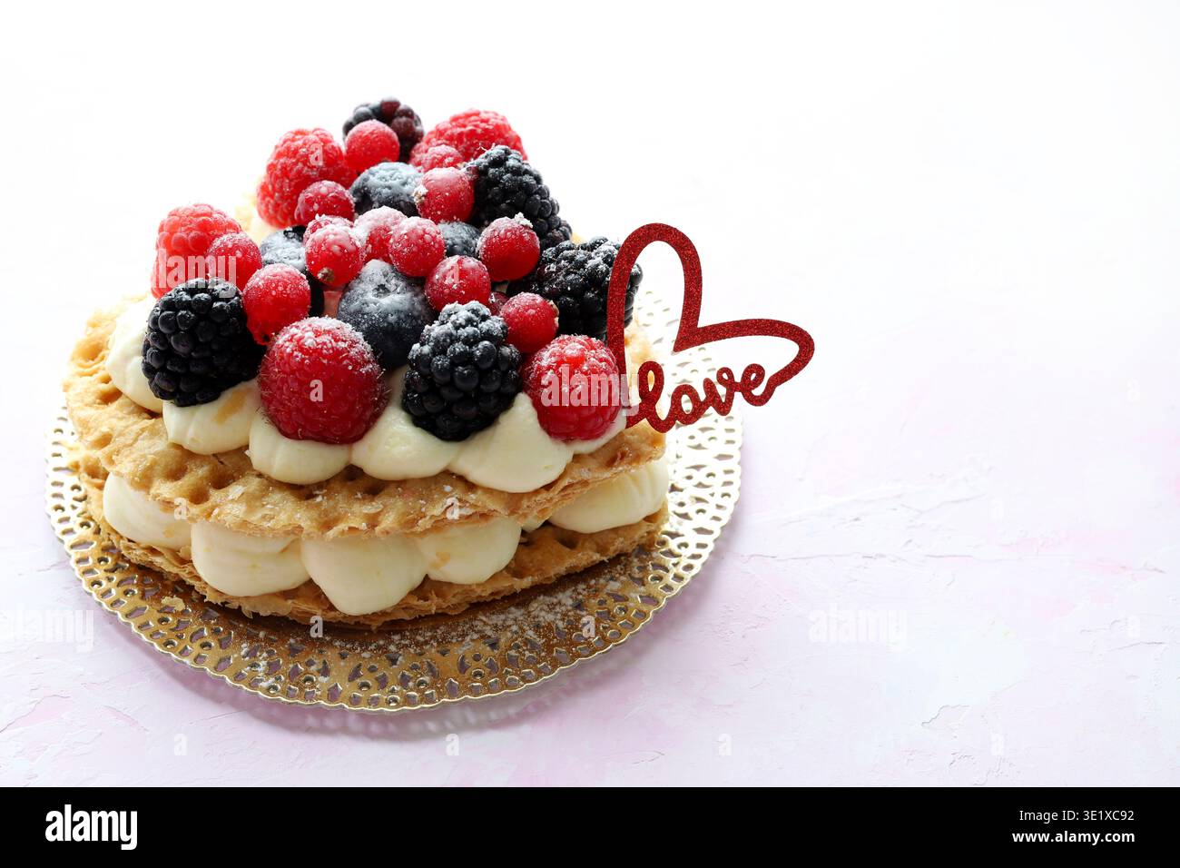 Valentinstag. Köstliche herzförmige Fruchttorte mit frischen Beeren und Puderzucker, herzförmige Dekoration. Draufsicht. Stockfoto