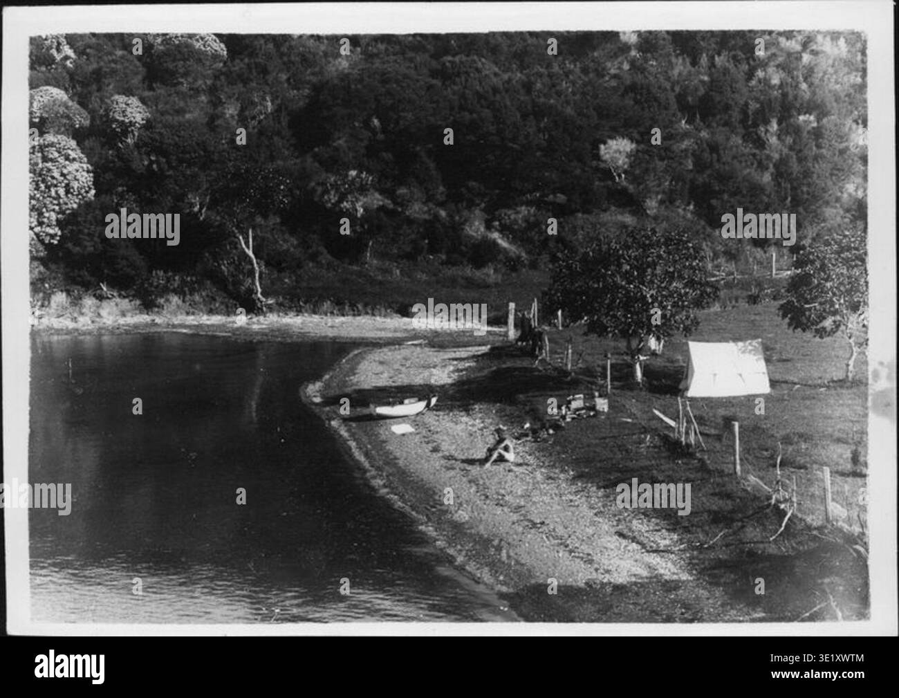 Camp at North Middle Point ist ein Foto von Henry Winkelmann aus dem Jahr 1911, das einen Campingplatz in Opito Bay im Far North District in Neuseeland zeigt. Das archivierte Fotoarchiv dokumentiert die temporären Lagerstrukturen und die umgebende Bucht. Stockfoto