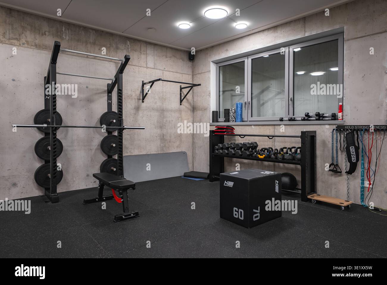 Beton-Fitnessraum im Dolomites Hotel Spa Gym mit Hockgestell Stockfoto