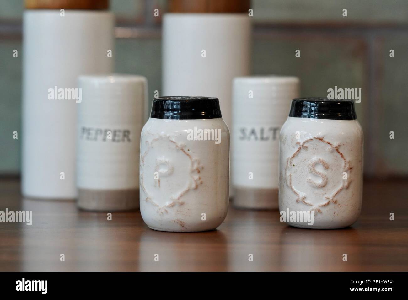 Sammlung von Salz- und Pfefferstreuern in einer rustikalen, modernen Bauernhausküche. Stockfoto