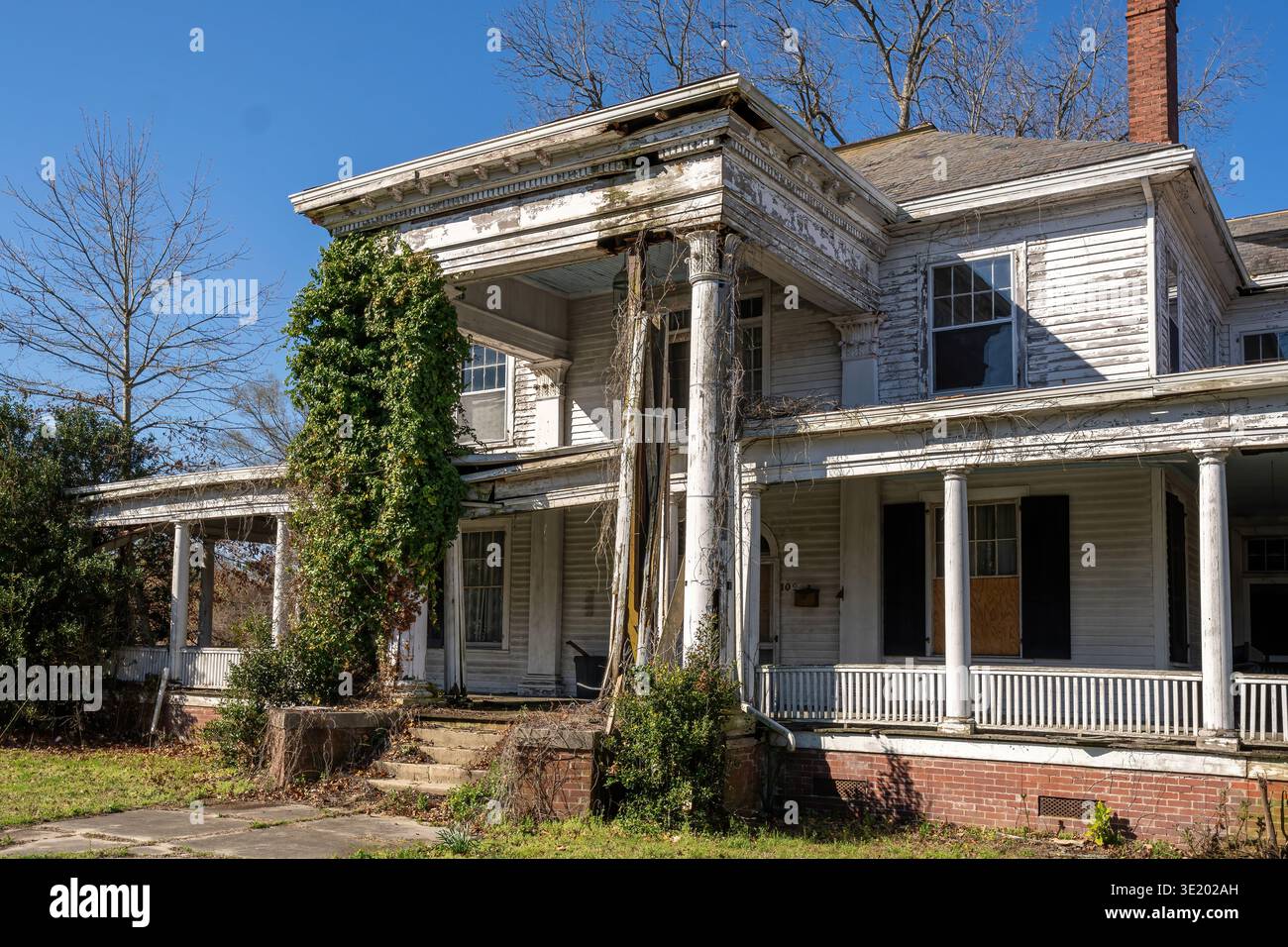 Robersonville, North Carolina, USA – altes, verlassenes historisches Haus mit Säulen und bewachsener Vegetation in einer kleinen Stadt. Stockfoto