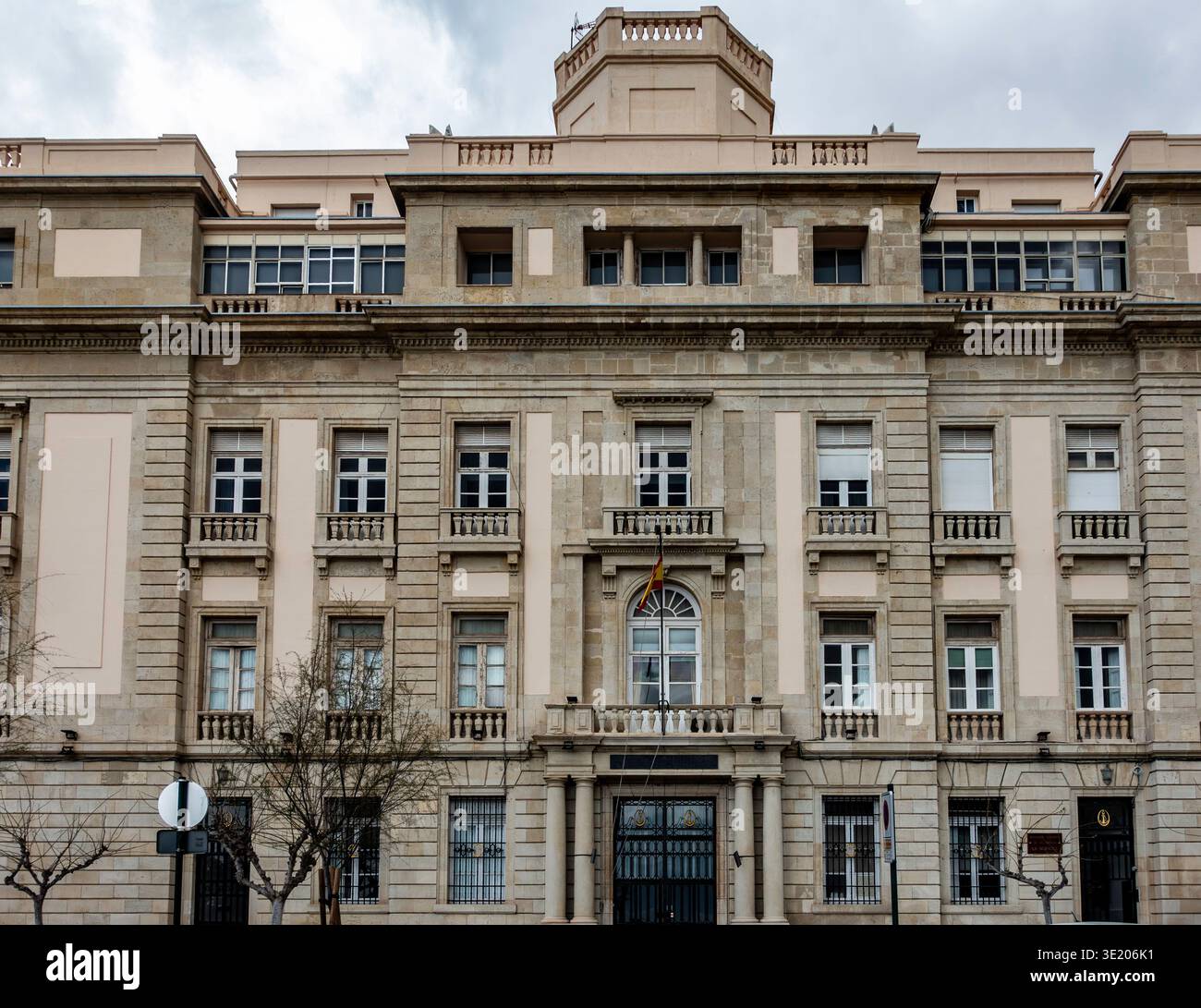 Die Steinfassade des Militärregierungsgebäudes in Cartagena, Spanien, verfügt über symmetrische Fenster, einen zentralen Balkon und eine spanische Flagge. Stockfoto