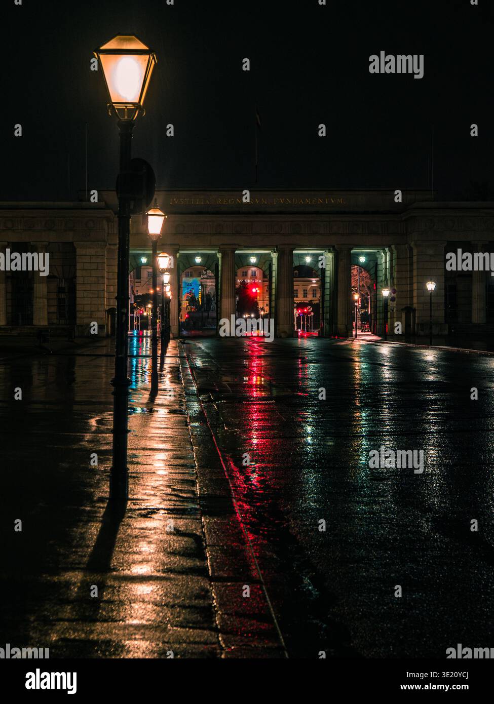 Heldenplatz Wien bei Nacht: Volks-Theater und MuseumsQuartier, beleuchtete Gebäude und nasser Bürgersteig, dramatische Lichter der Stadt. Stockfoto