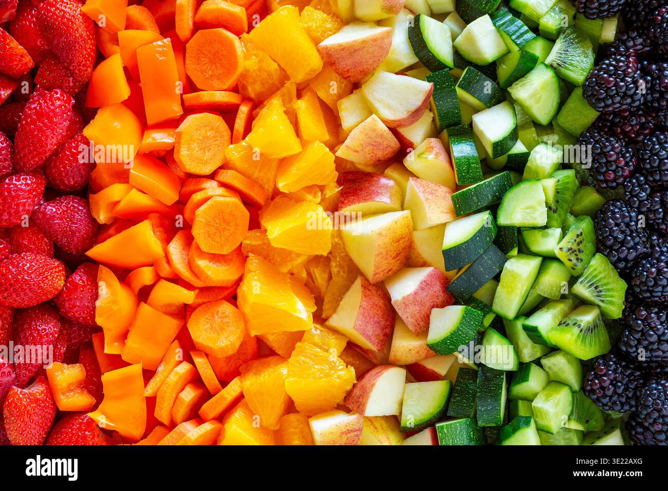 Farbenfrohe Auswahl an frischem Obst und Gemüse in einem Regenbogenverlauf. Stockfoto