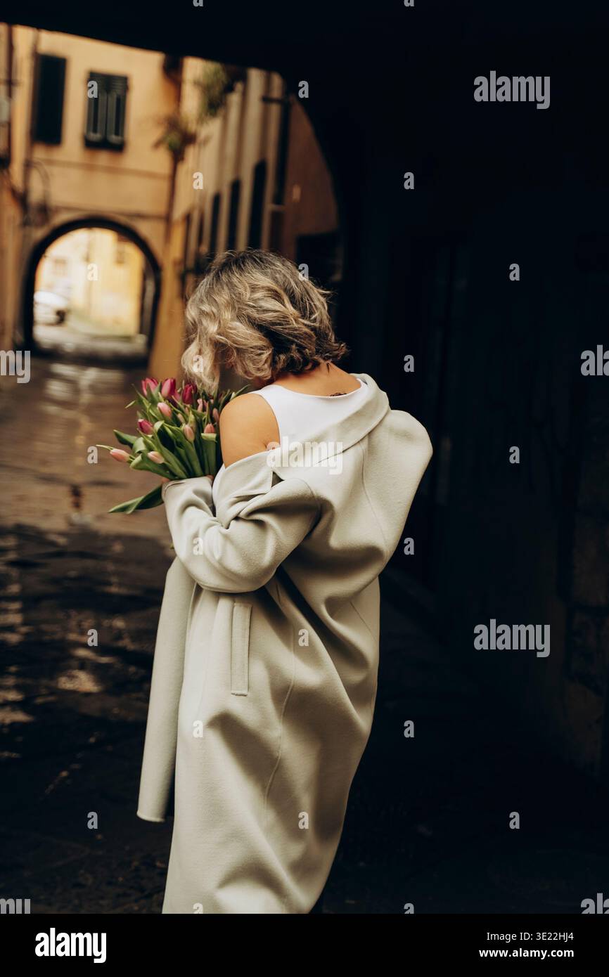 Frau, die Bouquet in der Gassen-Szene hält Stockfoto