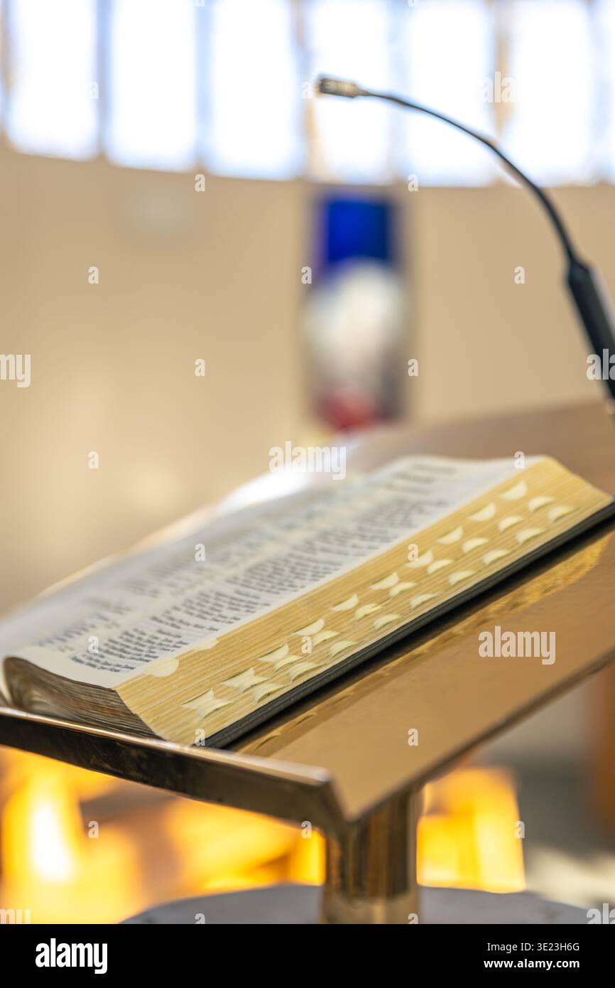 Bibel auf einem Rednerpult unter einem Mikrofon in einer hellen Kirche. Gesprochenes Wort. Stockfoto