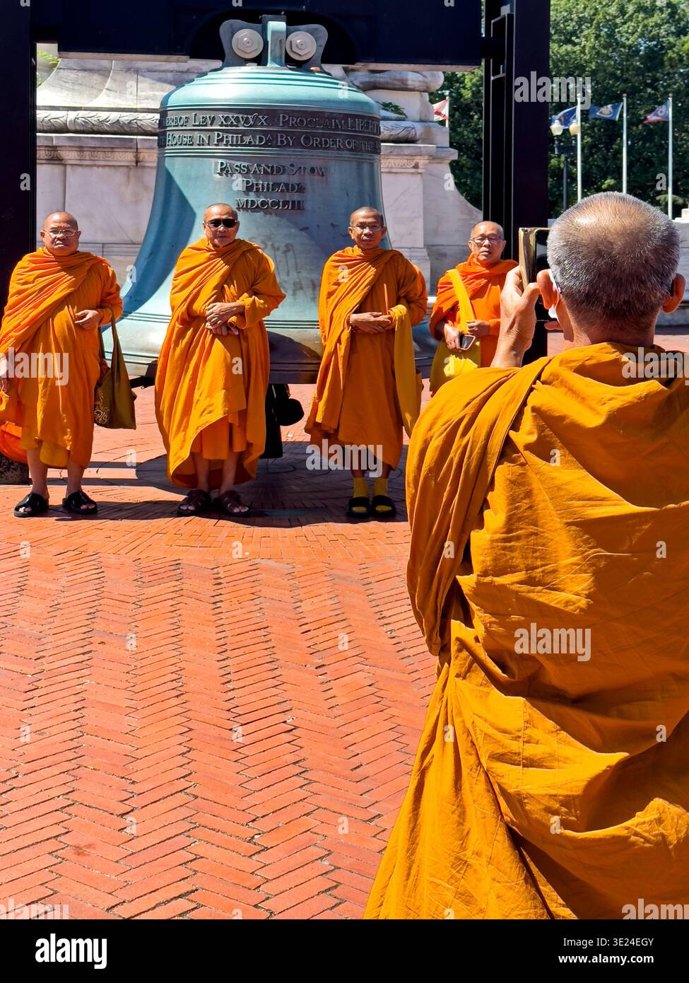 WASHINGTON, DC – 10. JUNI 2024: Ein buddhistischer Mönch fotografiert vier weitere Mönche vor der Freiheitsglocke auf der Union Station in Washington Stockfoto