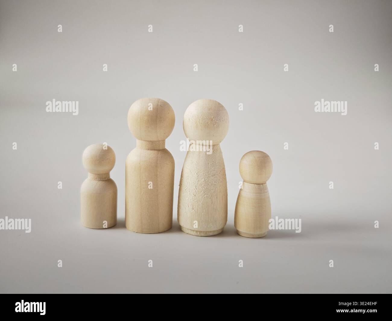 Holzpuppen sind so angeordnet, dass sie eine Familie mit Eltern und Kindern repräsentieren und ihre Bande der Einheit und Unterstützung im gemeinsamen Leben zeigen. Stockfoto