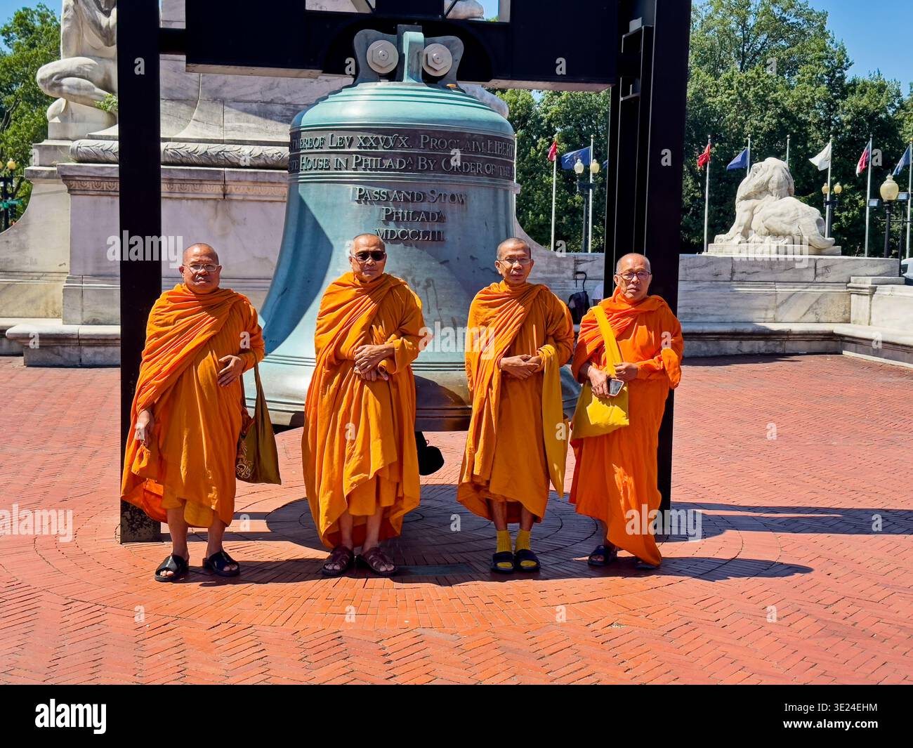 WASHINGTON, DC - 10. JUNI 2024: Vier buddhistische Mönche aus Asien posieren vor dem Freedom Bell Monument vor der Union Station in Washingto Stockfoto