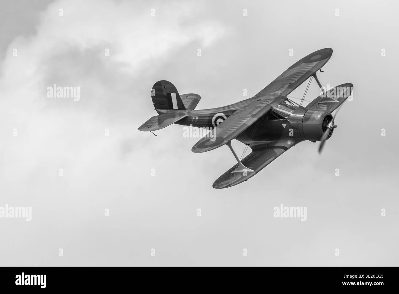 Headcorn Battle of Britain Airshow - Vintage-Doppeldecker der RAF im Flug gegen einen bewölkten Himmel in dramatischem Schwarz-weiß. Historisches Militär markin Stockfoto