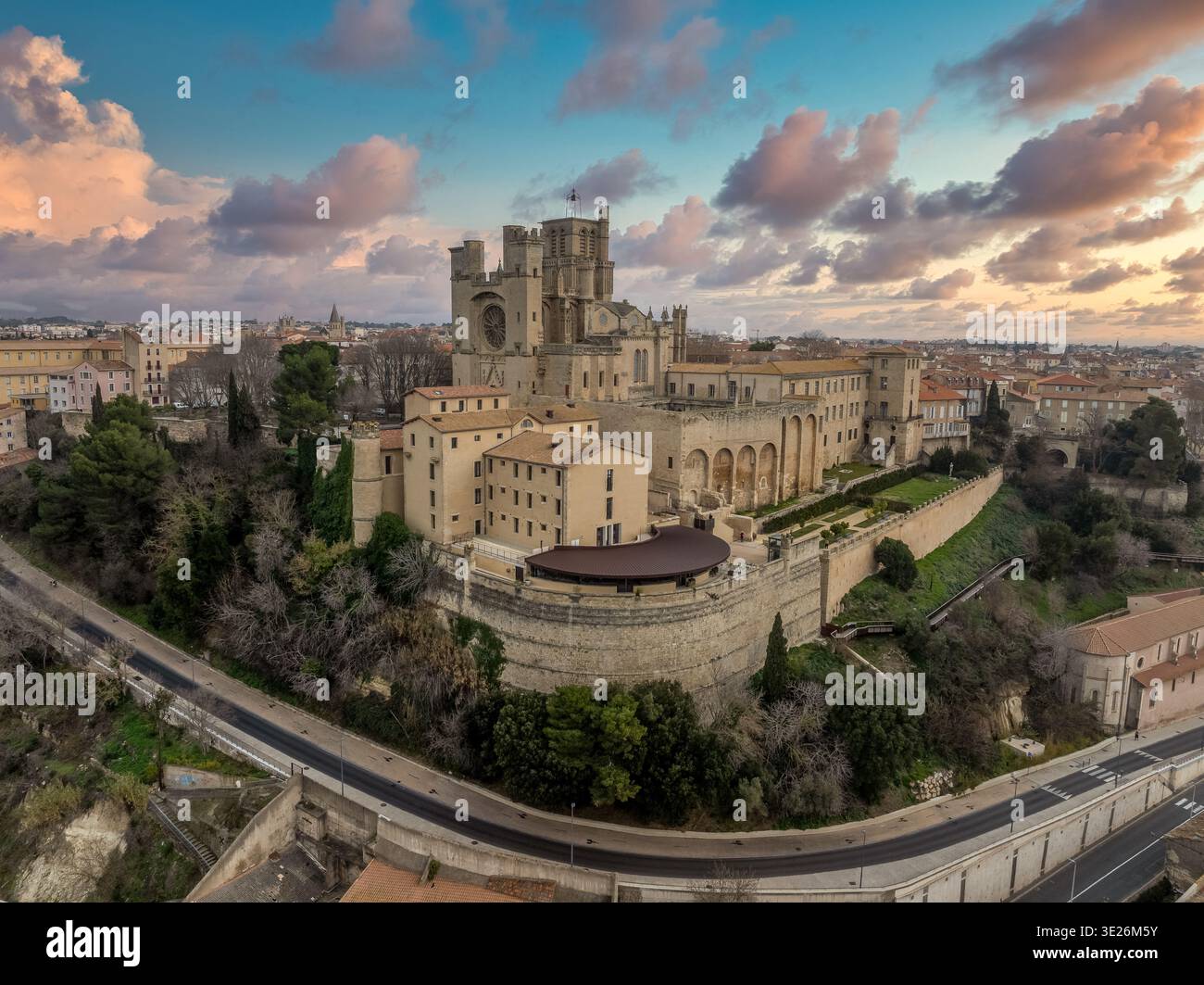 Entdecken Sie die Cathédrale Saint-Nazaire: Ein mittelalterliches Juwel auf einem Hügel in Béziers mit hoch aufragenden Rippengewölben und ikonischer Languedoc-Architektur mit Sonnenuntergang Stockfoto