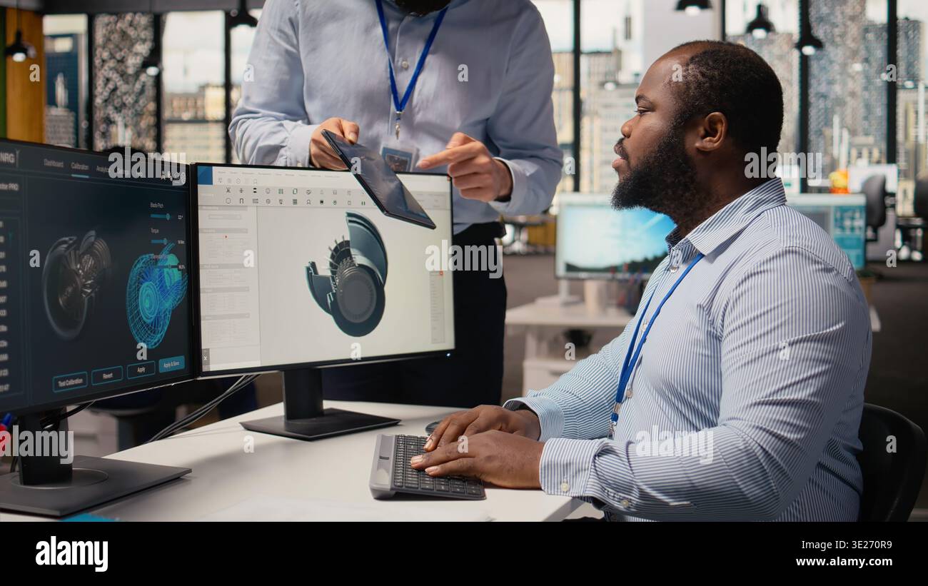 Manager, der den Ingenieur mit CAD-App zur Optimierung der Konstruktion von Windkraftanlagen beaufsichtigt und die CO2-Bilanz reduziert. Teamleiter und Mitarbeiter im RD-Büro testen fortschrittliche Materialien für umweltfreundliche Windmühlenteile, Kamera A Stockfoto