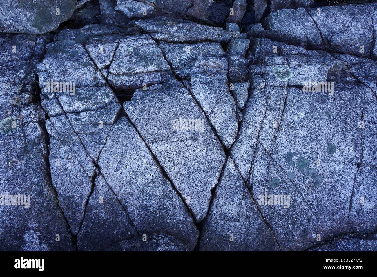 Ein großer, verwitterter Felsvorsprung mit einzigartigen geologischen Streifen steht an einem Kiesstrand entlang der zerklüfteten Küste von British Columbia Stockfoto