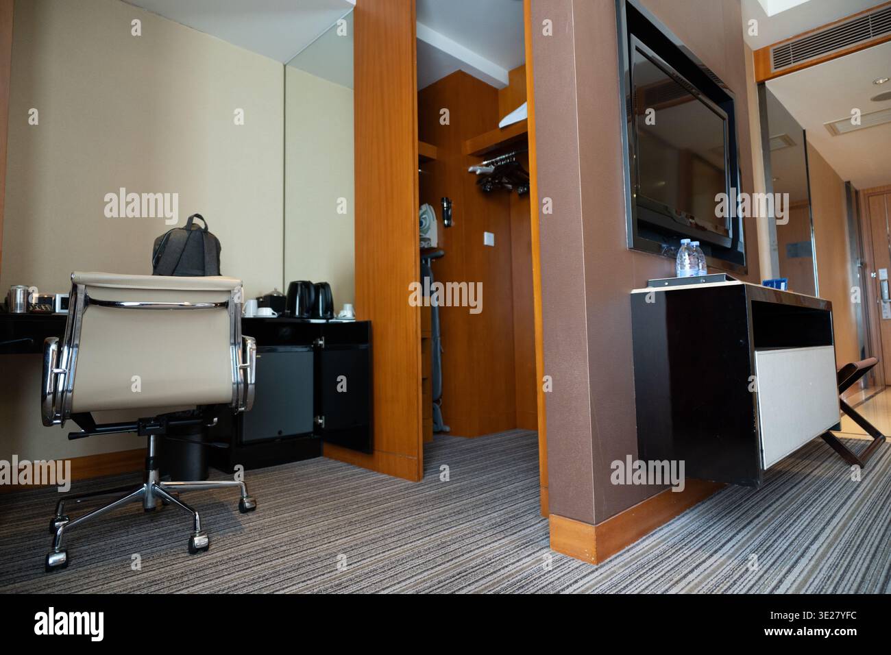 Modernes Hotelzimmer mit Bürostuhl, Flachbildfernseher und Holzakzenten in Singapur Stockfoto