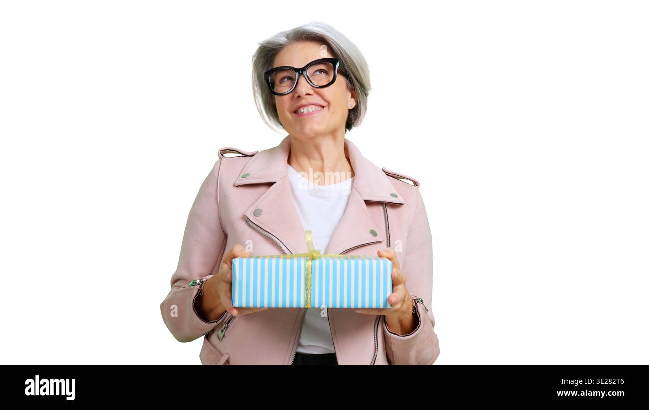 Lächelnde Seniorin in der Hand einer Geschenkbox Stockfoto