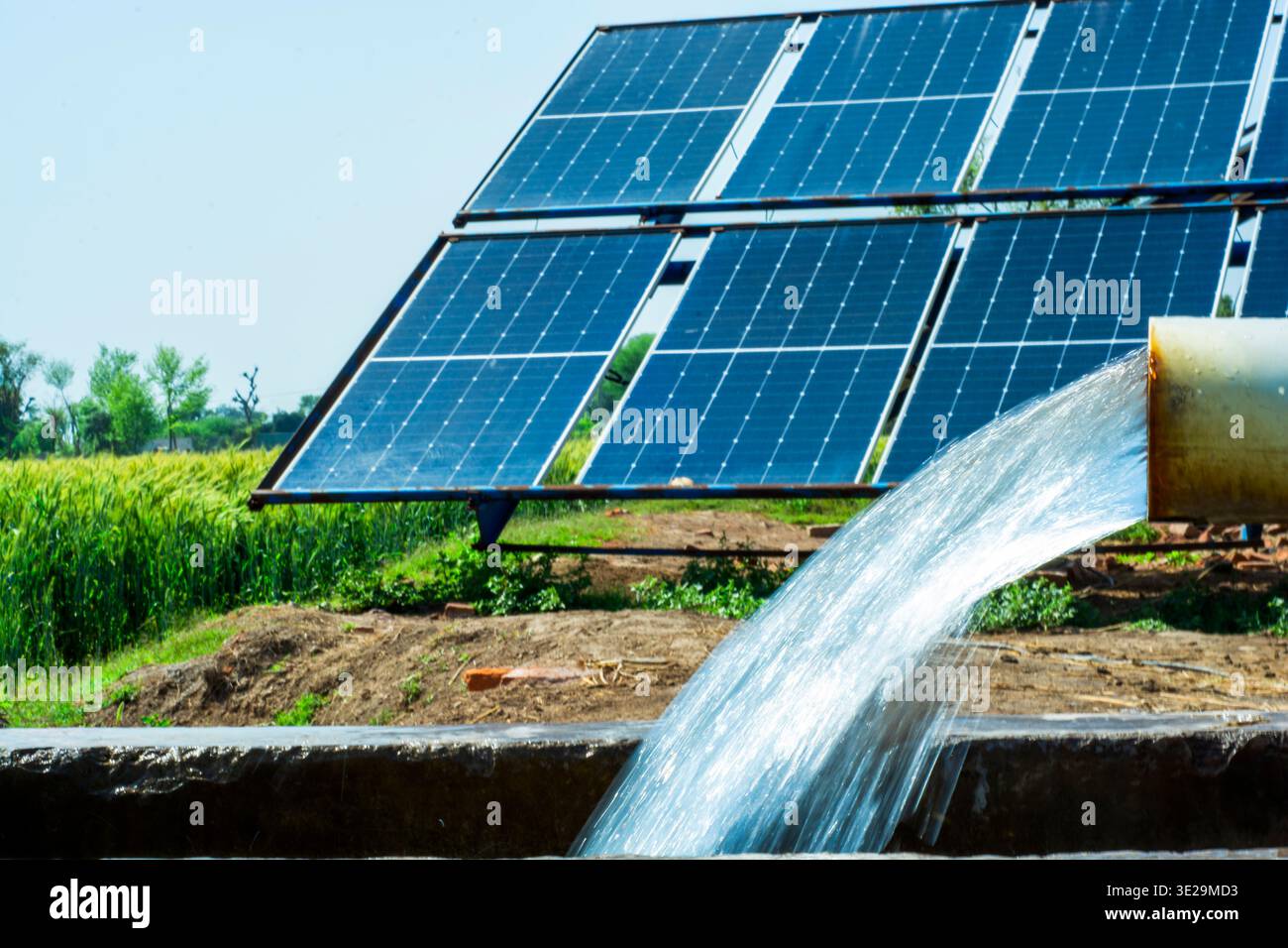Ein moderner Solarröhrenbrunnen versorgt die Feldfrüchte mitten auf einem weiten Agrarfeld mit Wasser. Stockfoto