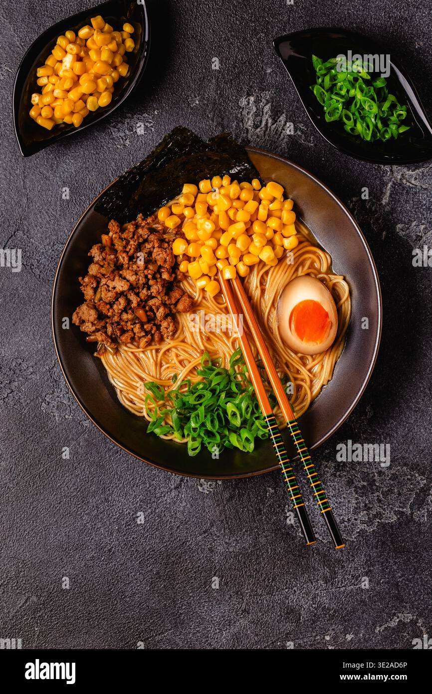 Eine Schüssel Ramen mit Nudeln, Fleisch und grünen Zwiebeln, Blick von oben. Stockfoto