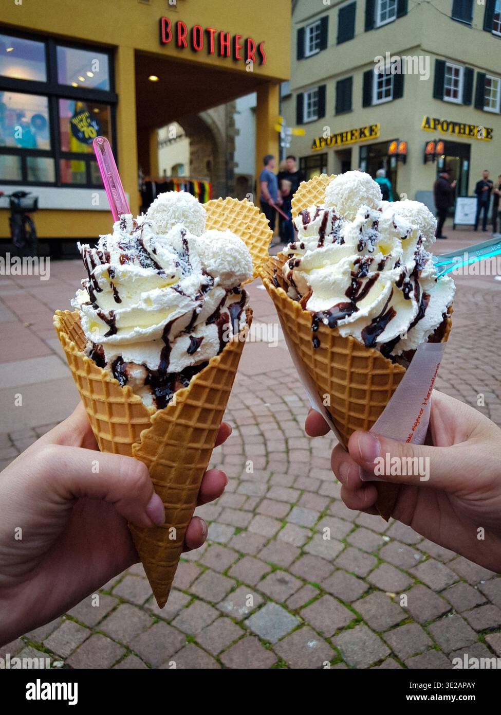 Zwei große Eiskegel mit Schlagsahne und Schokoladensauce Stockfoto