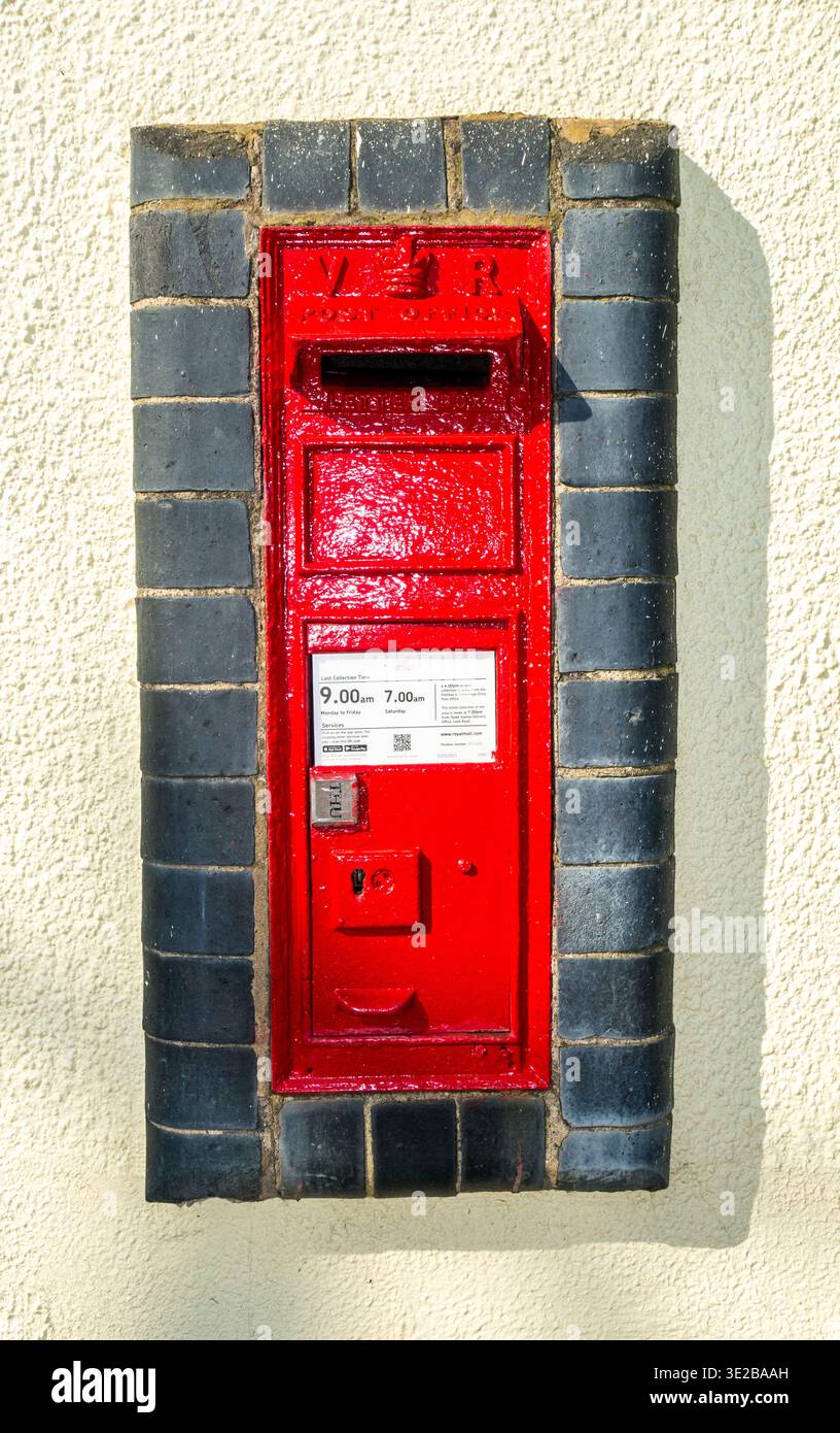 Traditioneller roter Briefkasten zur Wandmontage aus der Zeit von Königin Victoria im Dorf Butterton Newcastle in Staffordshire unter Lyme Stockfoto
