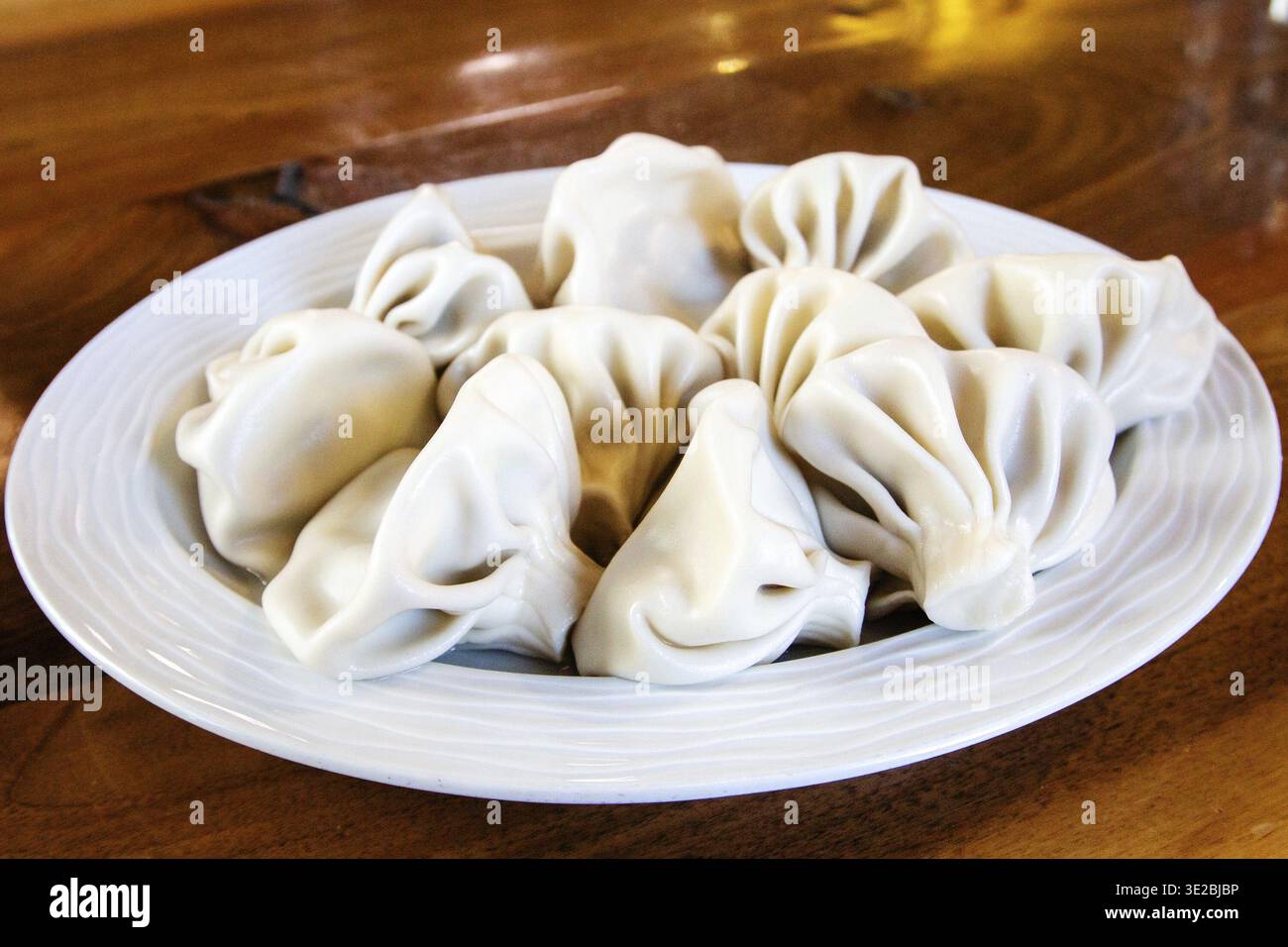 Reisen Sie nach Georgien - großer Teil des gekochten Khinkali (georgianische Knödel) auf einem Teller auf einem Holztisch im lokalen Café in Batumi City Stockfoto