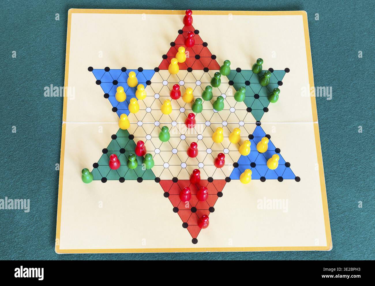 Drei-Spieler-Gameboard des Diamantspiels (Variante des chinesischen Checkers, Variante des Halma-Strategiespiels) auf grünem Baize-Tisch Stockfoto