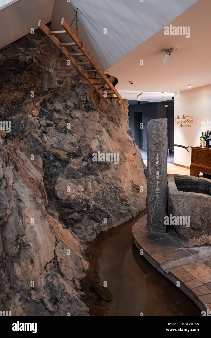 Indoor Alpine Spa mit Felswand und Holzleiter in Oberlech, Österreich Stockfoto