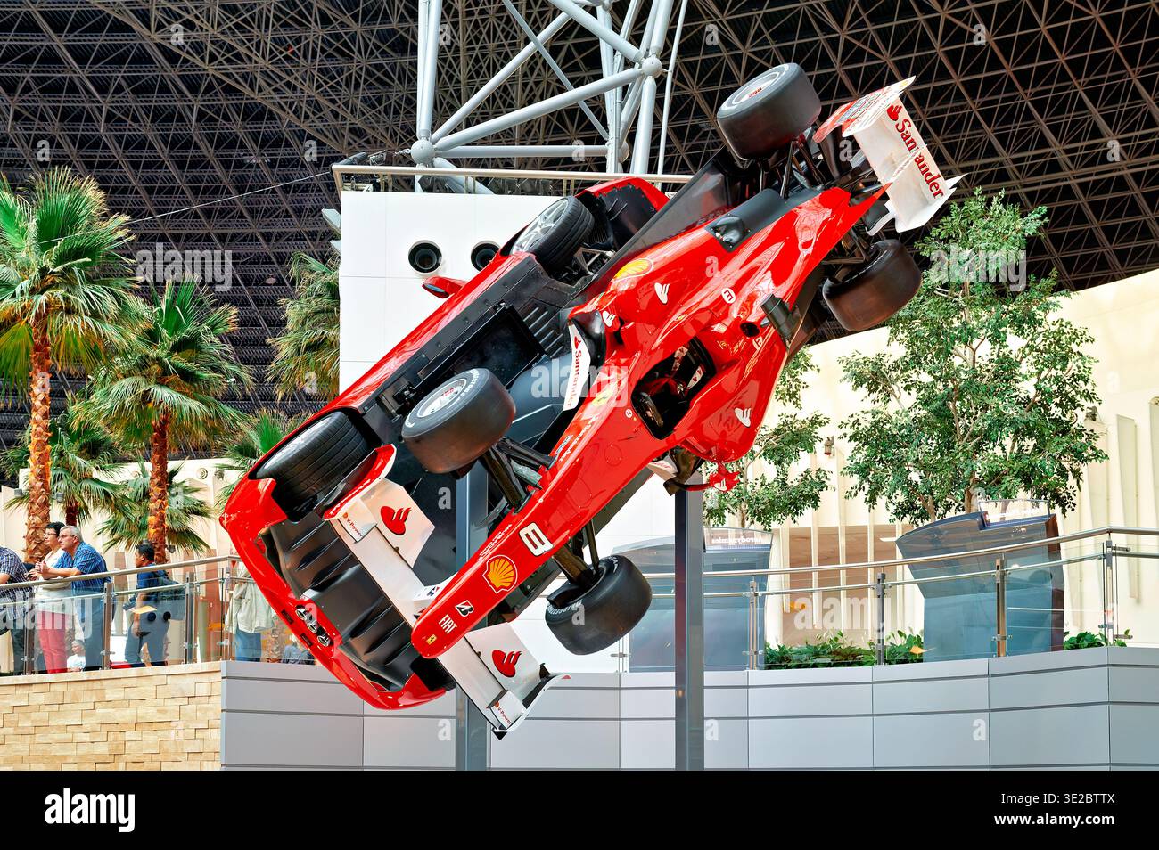 Besucher sehen eine Ferrari-Ausstellung auf der Ferrari World in Abu Dhabi. Das Fahrzeug wird verkehrt herum im Park gezeigt. Stockfoto