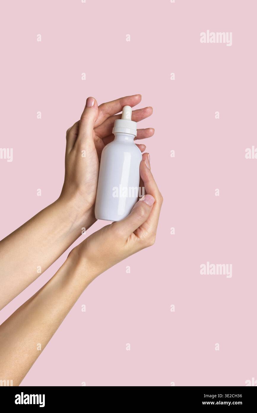 Frau Hand zeigt Creme Produkt. Mockup für das Branding von Kosmetikprodukten. Tägliche Hautpflege und Körperpflegeroutine. Weibliche Hand, die kosmetisches Produkt-Modell hält Stockfoto