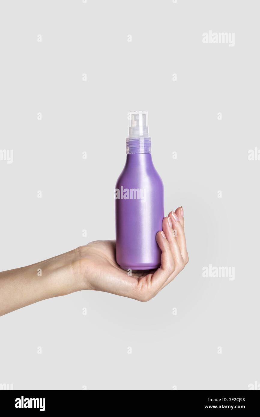 Frau Hand zeigt Creme Produkt. Mockup für das Branding von Kosmetikprodukten. Tägliche Hautpflege und Körperpflegeroutine. Weibliche Hand, die kosmetisches Produkt-Modell hält Stockfoto