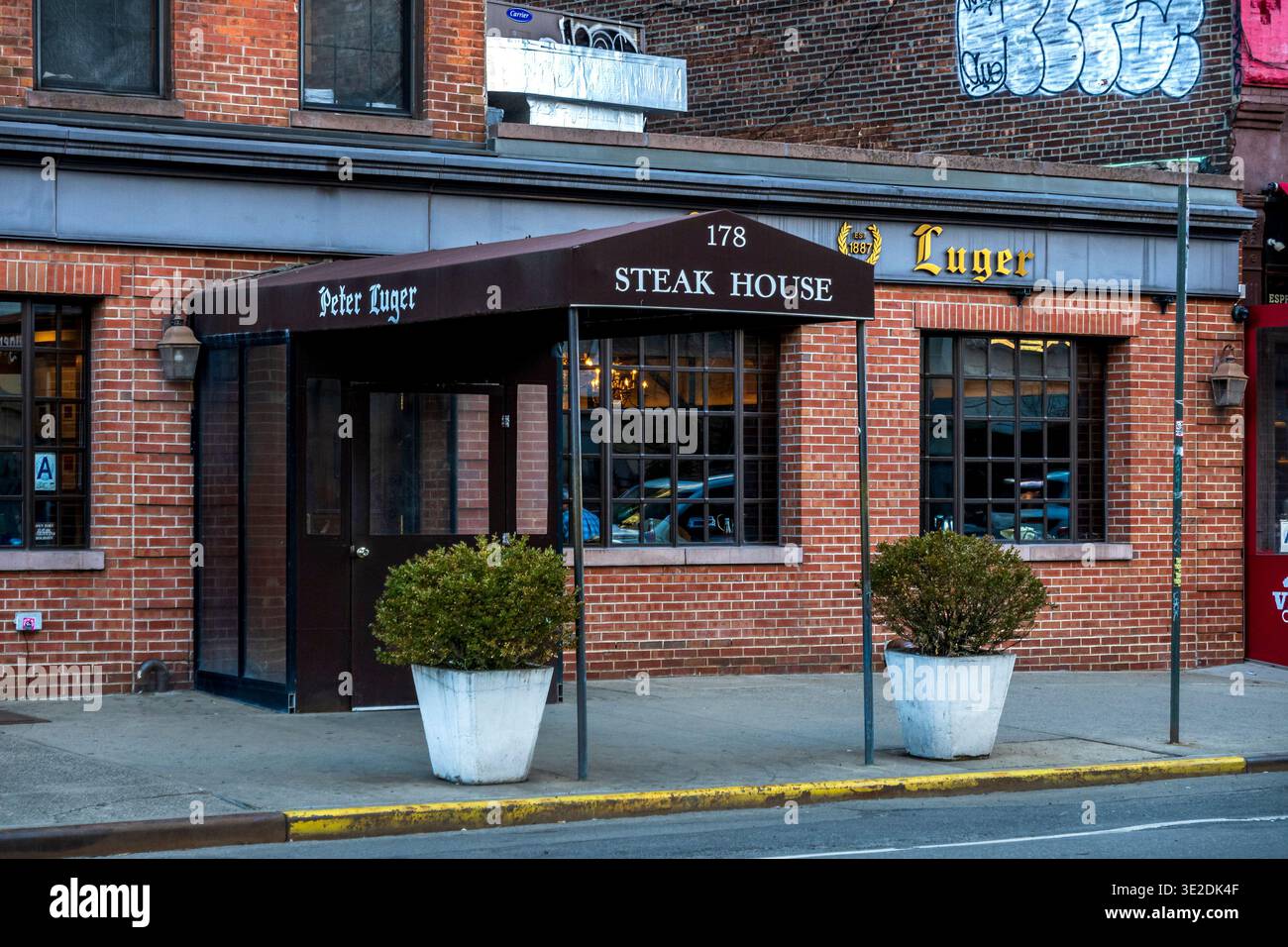 Brooklyn, NY - USA - 14. März 2026 Klassische Fassade des Peter Luger Steak House in Williamsburg, Brooklyn, mit ikonischer Markise, Backsteinfassade und ruhiger Straße Stockfoto