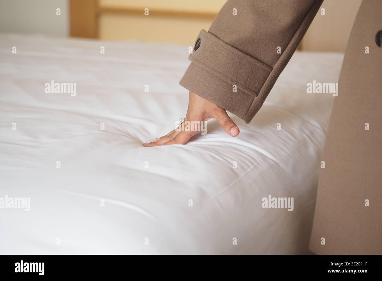 Drücken Sie die Hände in einem Zimmer auf eine weiche Bettwäsche Stockfoto