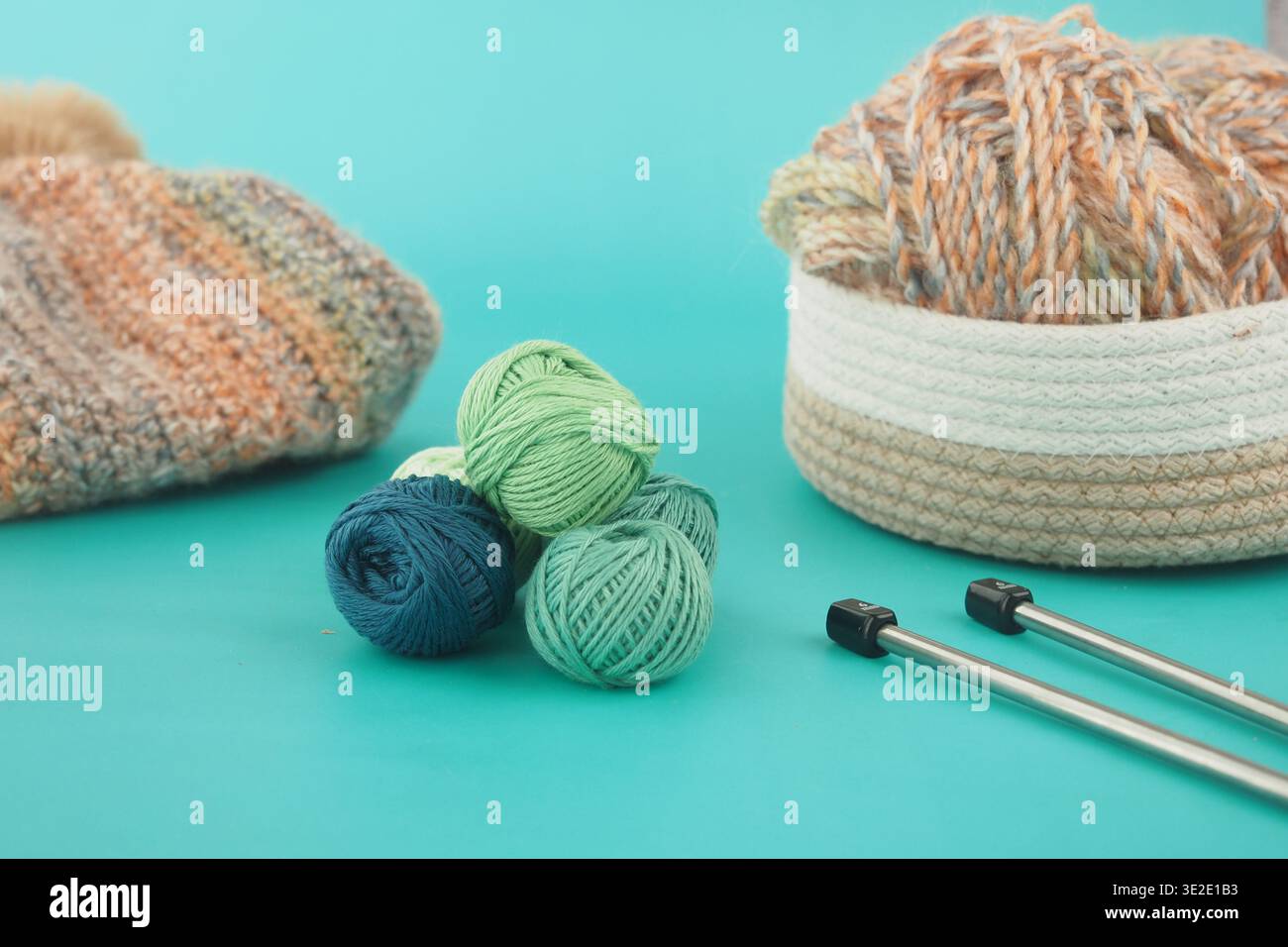 Strickeinrichtung mit Garn und Werkzeugen auf blauem Hintergrund Stockfoto