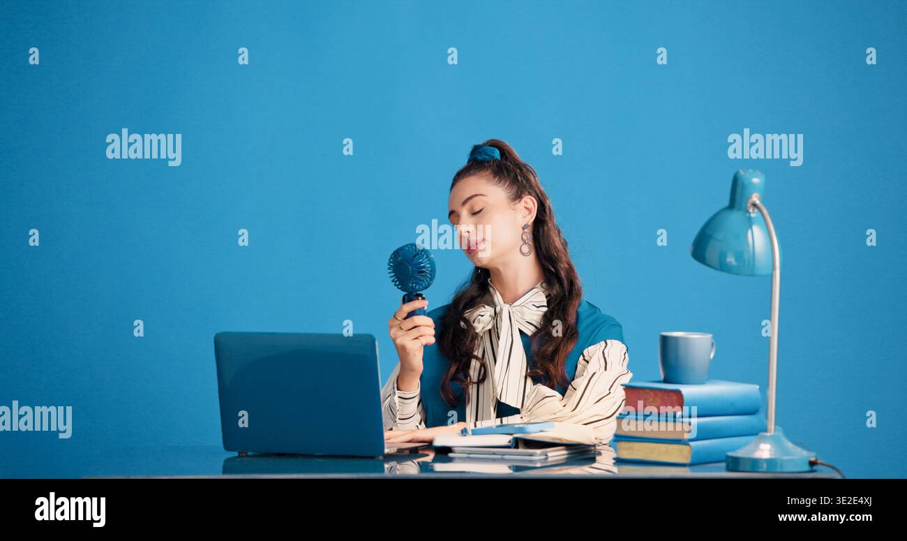 Ruhig, Frau und Schüler mit Ventilator für Wärme, Bildung und Entspannung mit Brise auf Pause und Mockup Raum. Blaue Wand, lernen und Person mit Mini-Luft Stockfoto