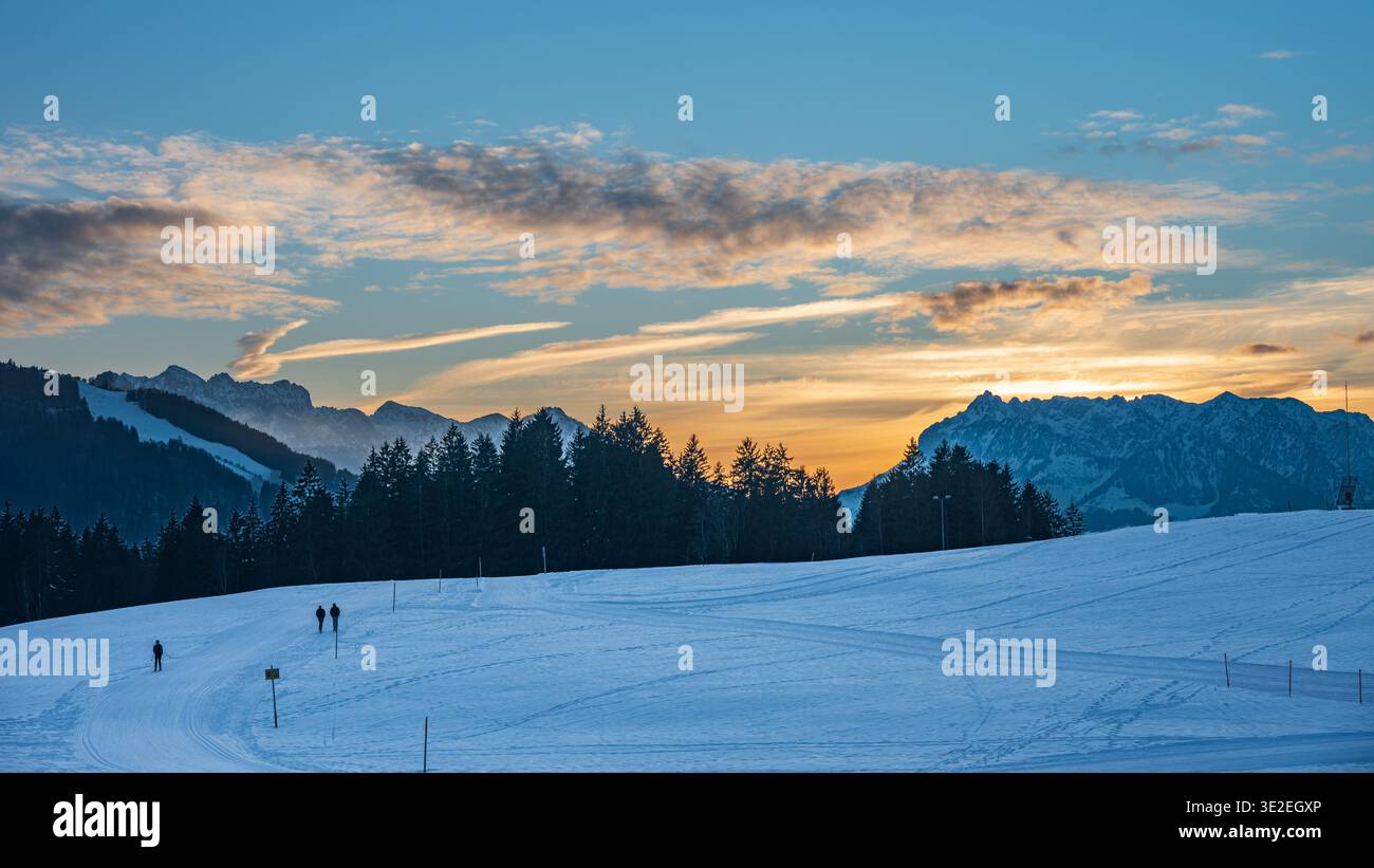 Winterlandschaft mit Wander- und Langlaufloipen in Reit im Winkl, Alpen, Deutschland, bei Sonnenuntergang. Blick auf die österreichischen Berge Zahmer Kaiser Stockfoto