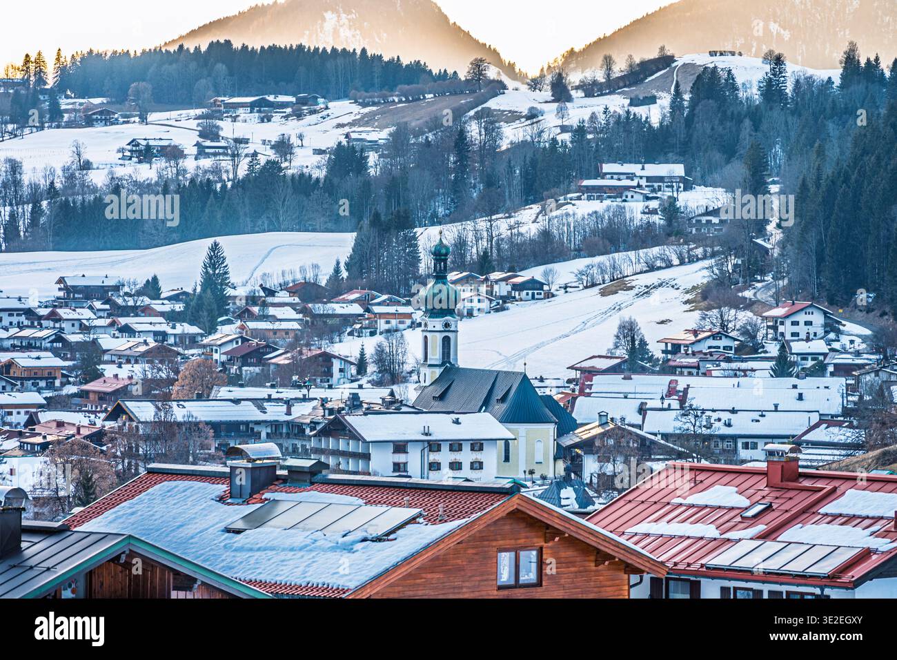 REIT im Winkl Wintersportort, Blick auf die Stadt mit Kirche bei Sonnenuntergang. Deutschland alpen. Stockfoto