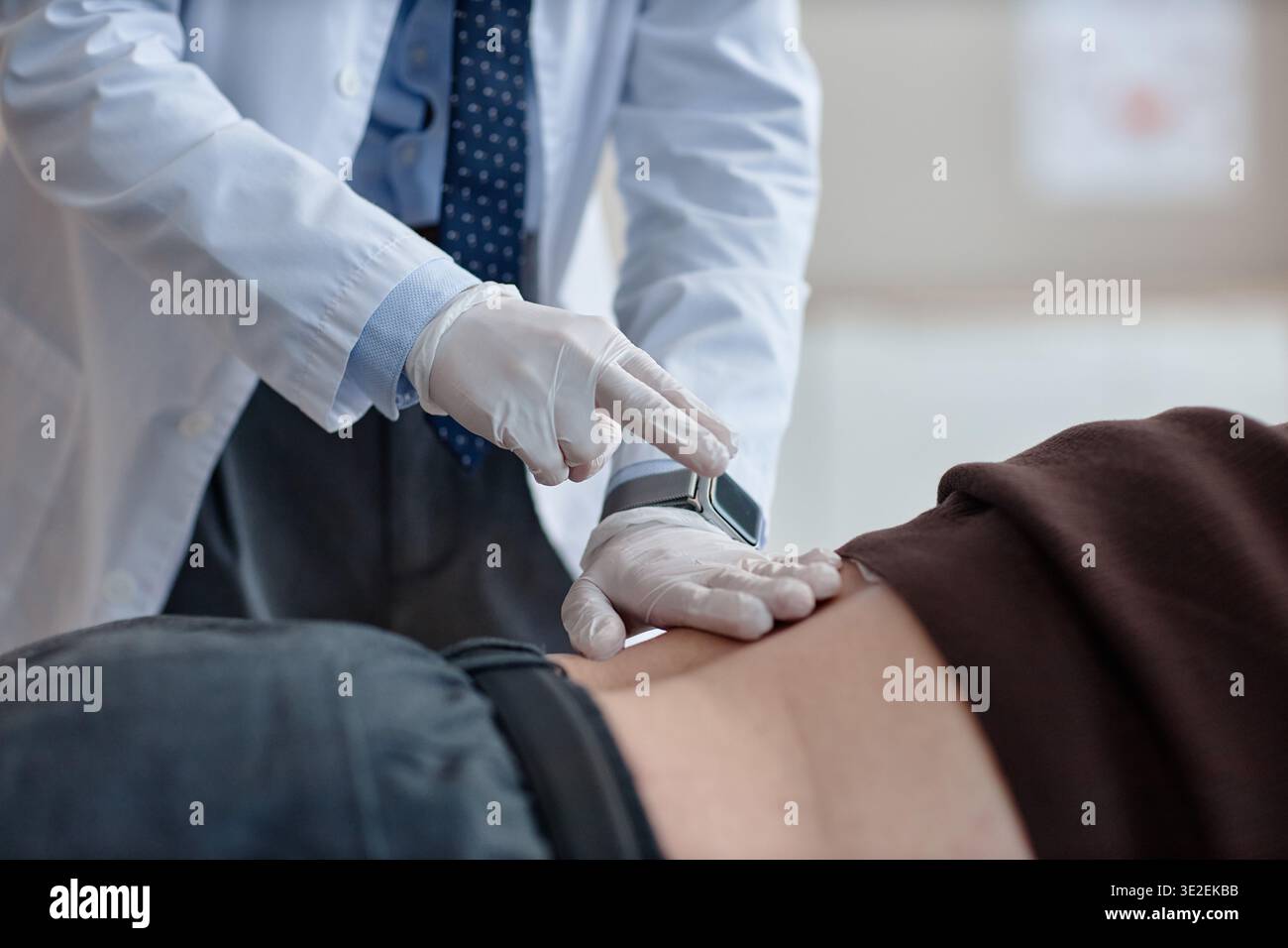 Urologe untersucht Rücken eines erwachsenen männlichen Patienten Stockfoto