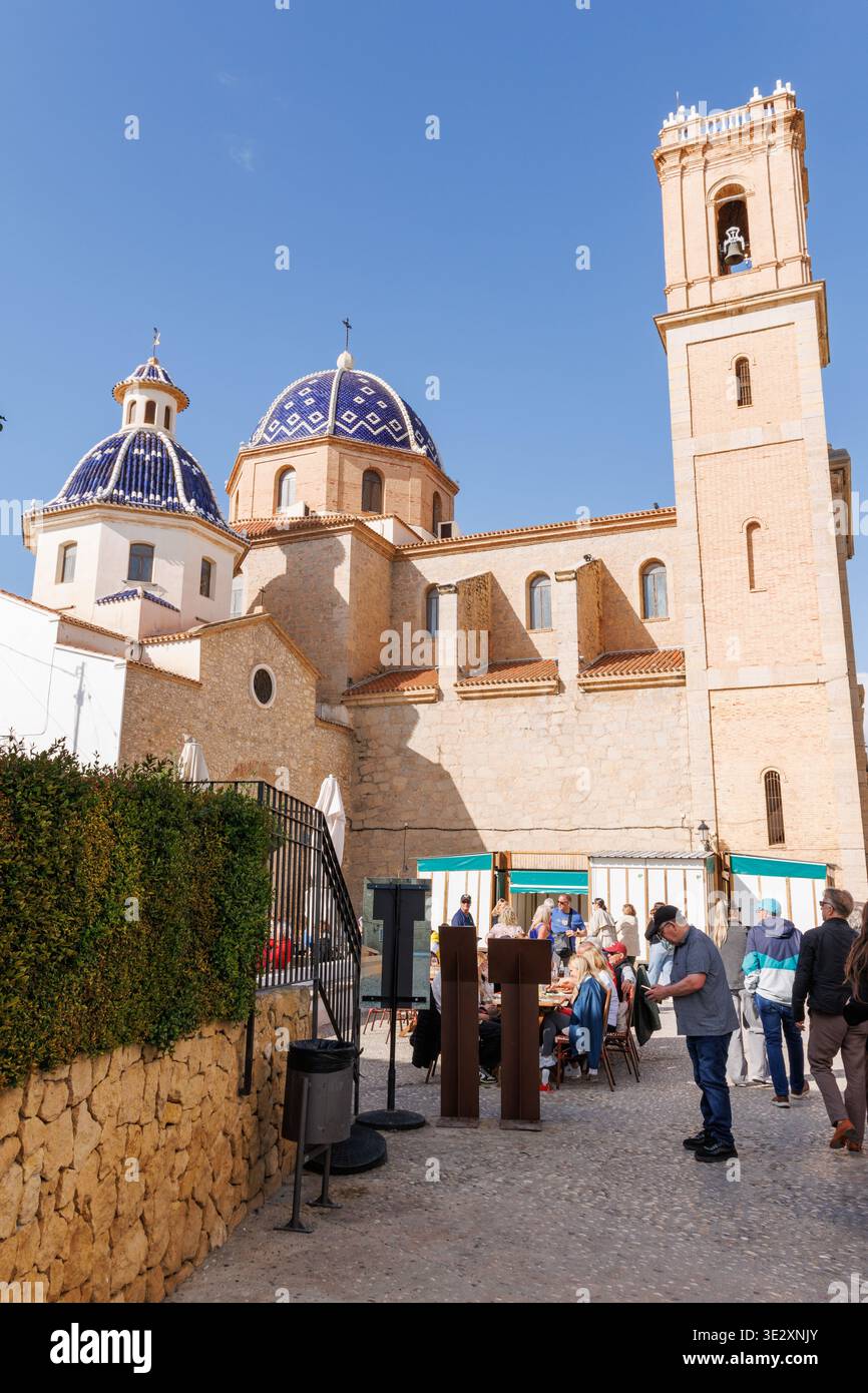 Touristen und Bürger auf dem Kirchplatz vor der Pfarrei Nuestra Senora del Consuelo in Altea am 19. März 2026, Spanien Stockfoto
