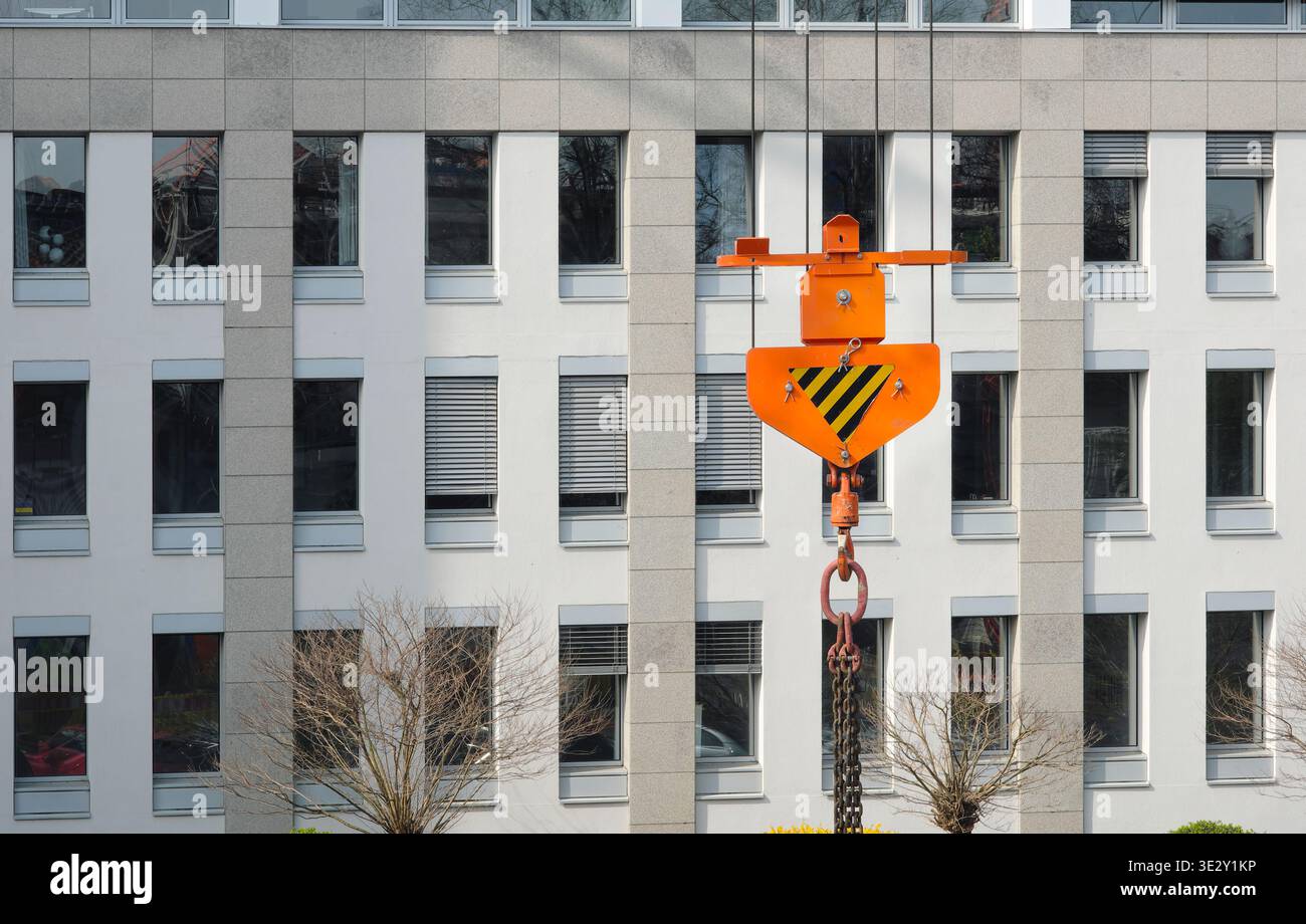 Kranhaken vor dem Geschäftsgebäude, der Industrie, der Baustelle, der Architektur, der Immobilienentwicklung, der freien Kopierfläche Stockfoto