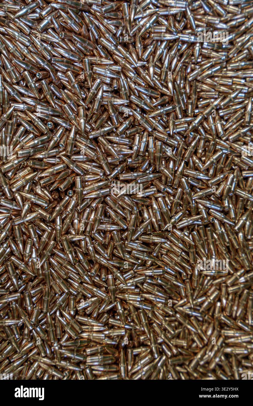 Großer Haufen von Gewehrkugeln und Kupfermunitionskomponenten in einer Fabrik oder einem Waffenbereich, Militärbedarf und Herstellungskonzept für Ballistik. Hoch q Stockfoto