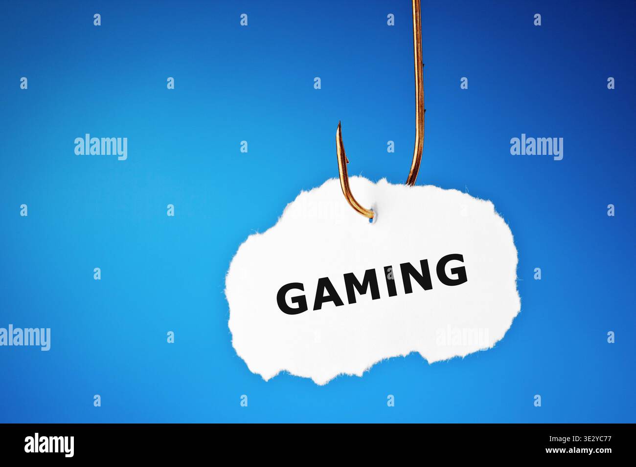 Konzeptuelles Bild über das Risiko von Videospielsucht und Internet-Gaming-Störung. Ein Stück Papier mit gedrucktem Wort "Gaming" hängt an einem Angelhu Stockfoto